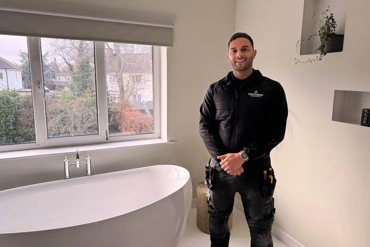Alex at Protherm Heating Solutions standing next to a new bath installation